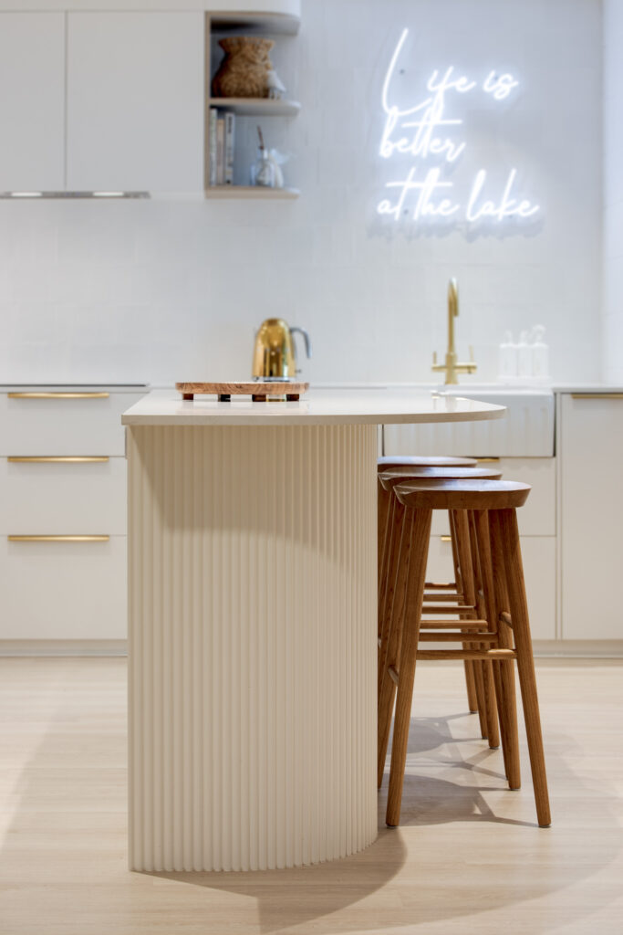 Photo of a newly renovated kitchen. White cabinets with gold handles.